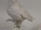 two small figurines of birds on a table