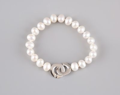 a white pearl bracelet with a silver heart charm