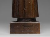 an old wooden statue of a man with a hat on his head