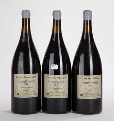 trois bouteilles de vin posées les unes à côté des autres sur une surface blanche