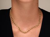 a close up of a woman wearing a black shirt and a gold chain necklace