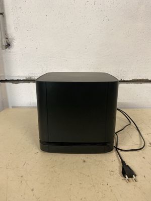 a small black box sitting on top of a table next to a wall