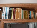 a book shelf with many books on it and a mirror