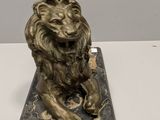 a statue of a lion sitting on a marble base