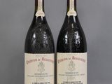 two bottles of wine sitting on top of a table next to each other