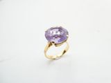 a close up of a ring with a purple stone on it