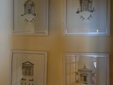quatre tableaux encadrés accrochés au mur d'une pièce