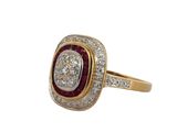 a close up of a diamond and ruby ring on a white background