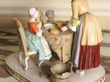 a figurine of a woman and two children sitting at a table