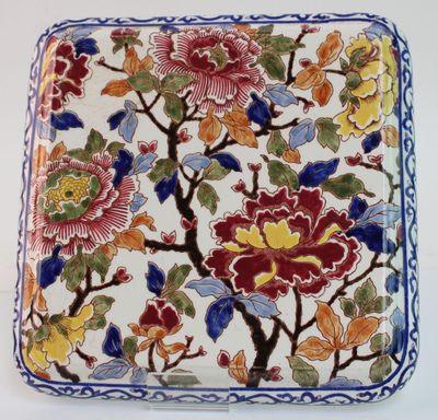 un gros plan d'une assiette décorée de fleurs et de feuilles