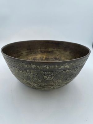 a close up of a metal bowl on a white surface