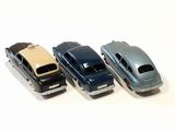 three toy cars are lined up in a row on a white surface