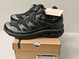 une paire de chaussures noires posée sur une boîte en carton
