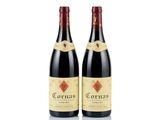 two bottles of red wine sitting next to each other on a white surface