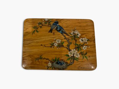 a wooden tray with a painting of a bird on it