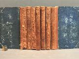several old books are stacked on top of each other on a table