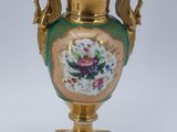 a gold vase with a floral design on it