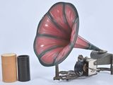 un gramophone rouge et noir posé à côté d'un rouleau de papier toilette