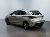 the back of a silver car in a room with a white wall