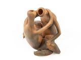 a clay sculpture of a monkey holding a vase