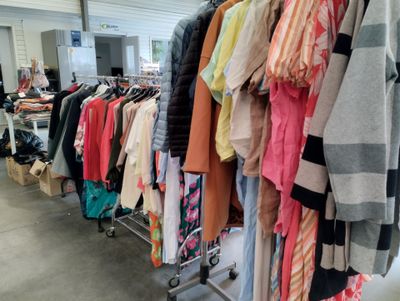 many clothes hanging on a rack in a room