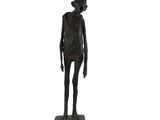 bronze statue of a man with a hat on his head and hands in his pockets