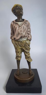 statue en bronze représentant un garçon portant un chapeau et une chemise, posée sur un socle noir
