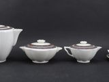 four pieces of porcelain tea and coffee set on a black background