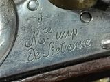 a close up of a gun with a gold handle