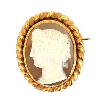 Une broche plaquée or représente le profil d'une femme.