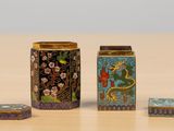 three different types of decorative boxes sitting on a wooden table