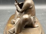 bronze statue of a boy with a hammer on a base
