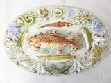 a plate with two fish on it and a snake on the plate