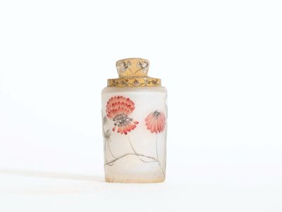 une petite bouteille en verre ornée d'un motif floral