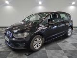 La Volkswagen Touran noire est garée dans une pièce au sol carrelé en damier.