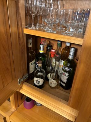 a wooden cabinet with wine glasses and bottles on it