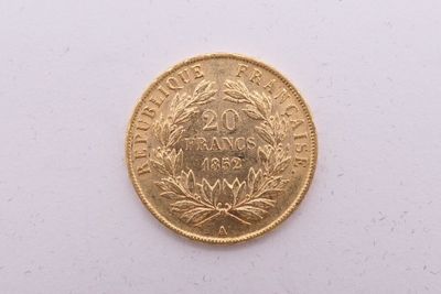 gros plan d'une pièce d'or sur une surface blanche