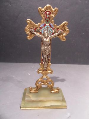 a gold cross with a blue and red design on it