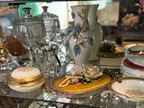 une étagère en verre sur laquelle sont disposés de nombreux types de vaisselle différents