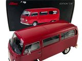 a red toy bus that is in front of a box