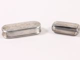 two small silver containers sitting on a white surface