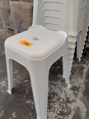 une pile de chaises en plastique blanc sur lesquelles est accrochée une étiquette de prix