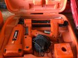 une boîte à outils orange contenant des outils, posée sur une table