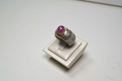 bague en argent ornée d'une pierre rose sur un fond blanc