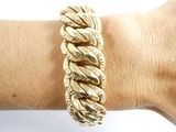 someone is wearing a gold bracelet with a chain on their arm