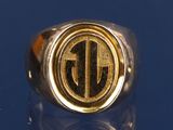 un gros plan d'une bague en or portant un monogramme