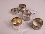 several silver cups and spoons sitting on a white surface
