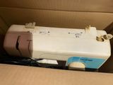 a sewing machine inside of a box with a cord