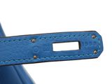 the handle of a blue handbag with a leather strap