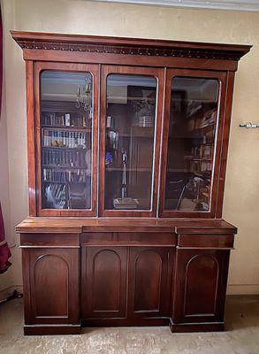 un grand meuble en bois avec des portes en verre dans une pièce